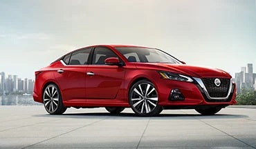 2023 Nissan Altima in red with city in background illustrating last year's 2022 model in Horace Nissan in Farmington NM